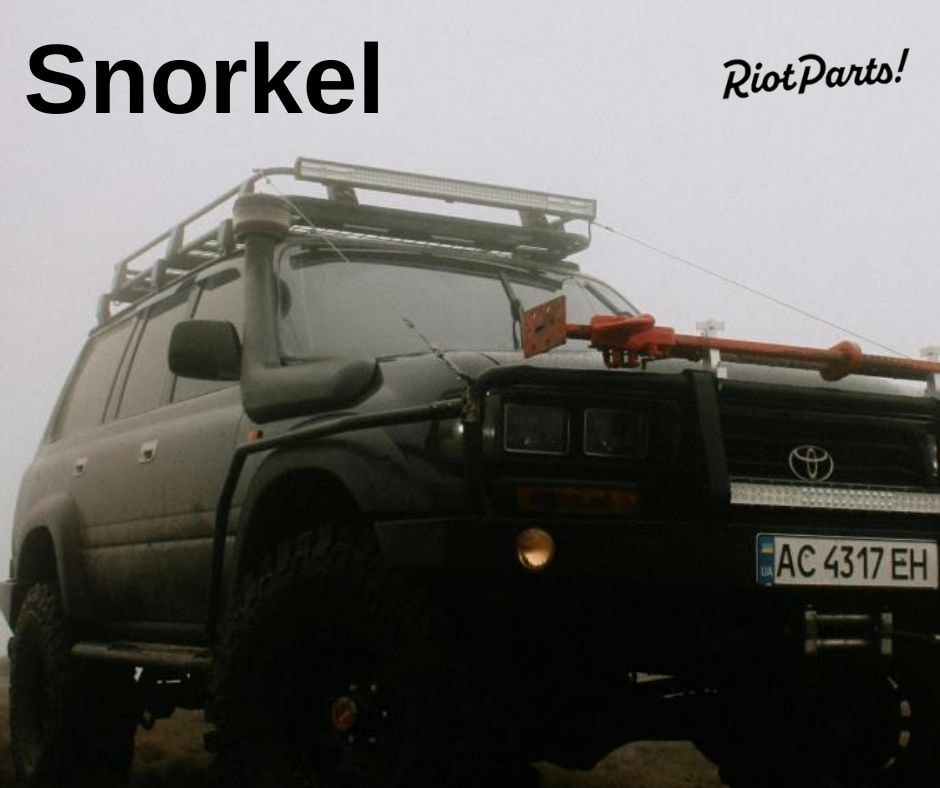 Toyota Land Cruiser with snorkel in a rugged, foggy setting.